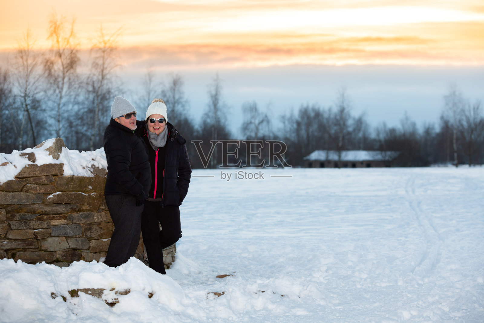 在寒冷的冬季，夫妻俩在户外享受一天的结束照片摄影图片