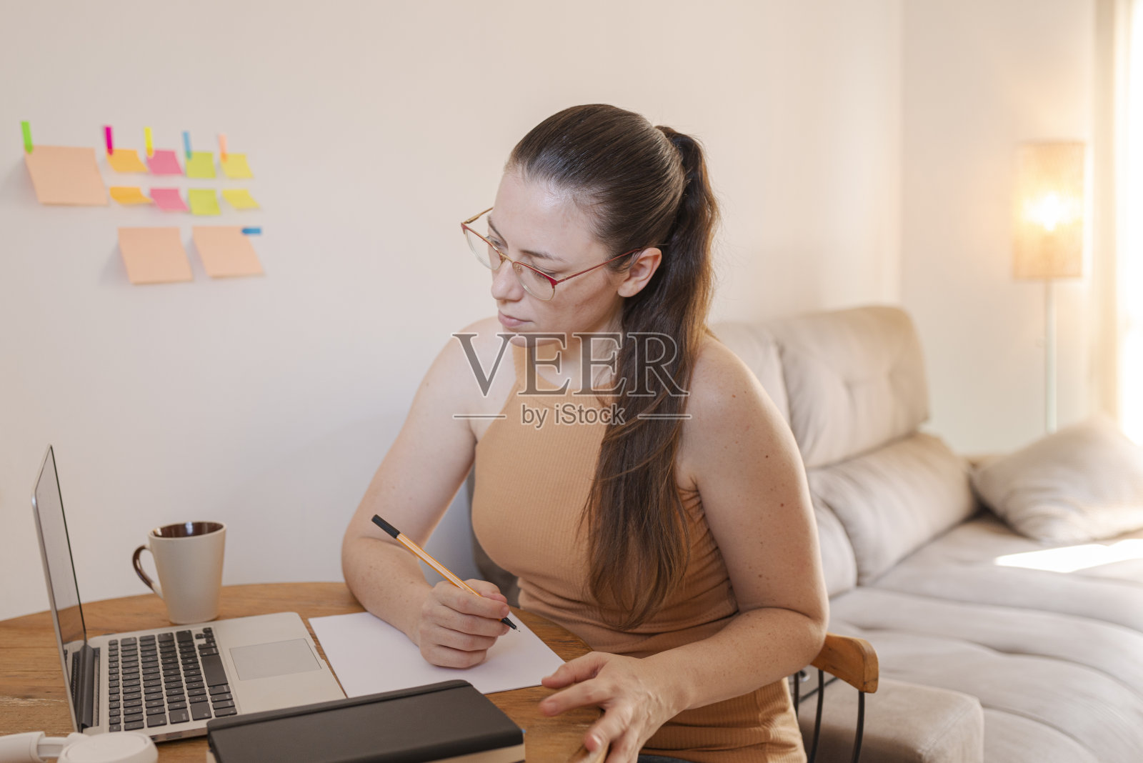 成年学生在他的客厅里学习照片摄影图片