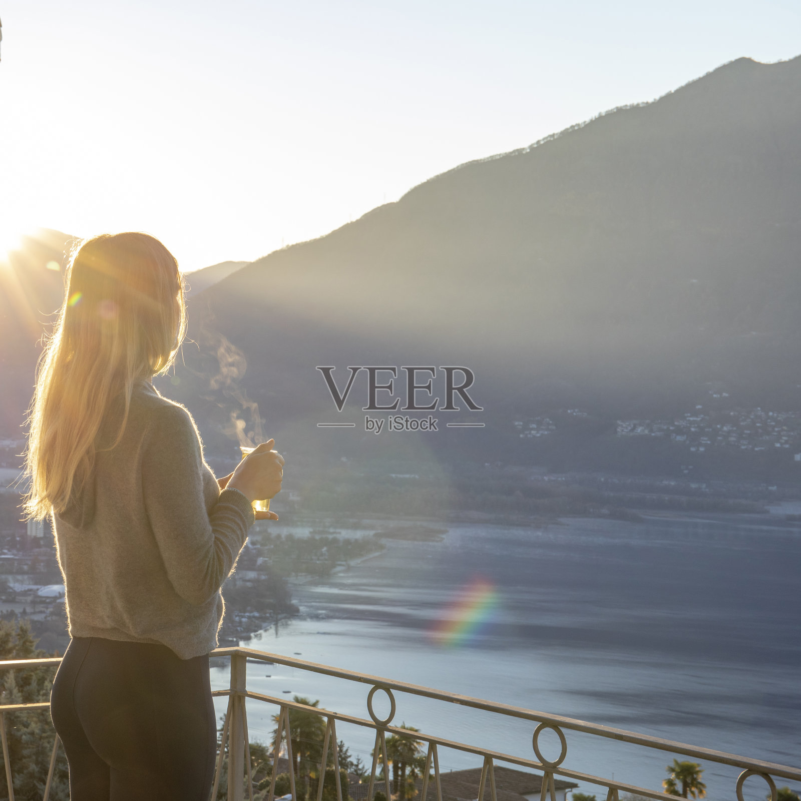 日出时分，年轻女子在阳台上休息照片摄影图片