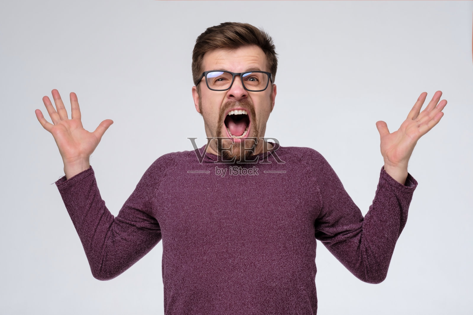 愤怒的白种人戴着眼镜尖叫着表示愤怒。照片摄影图片