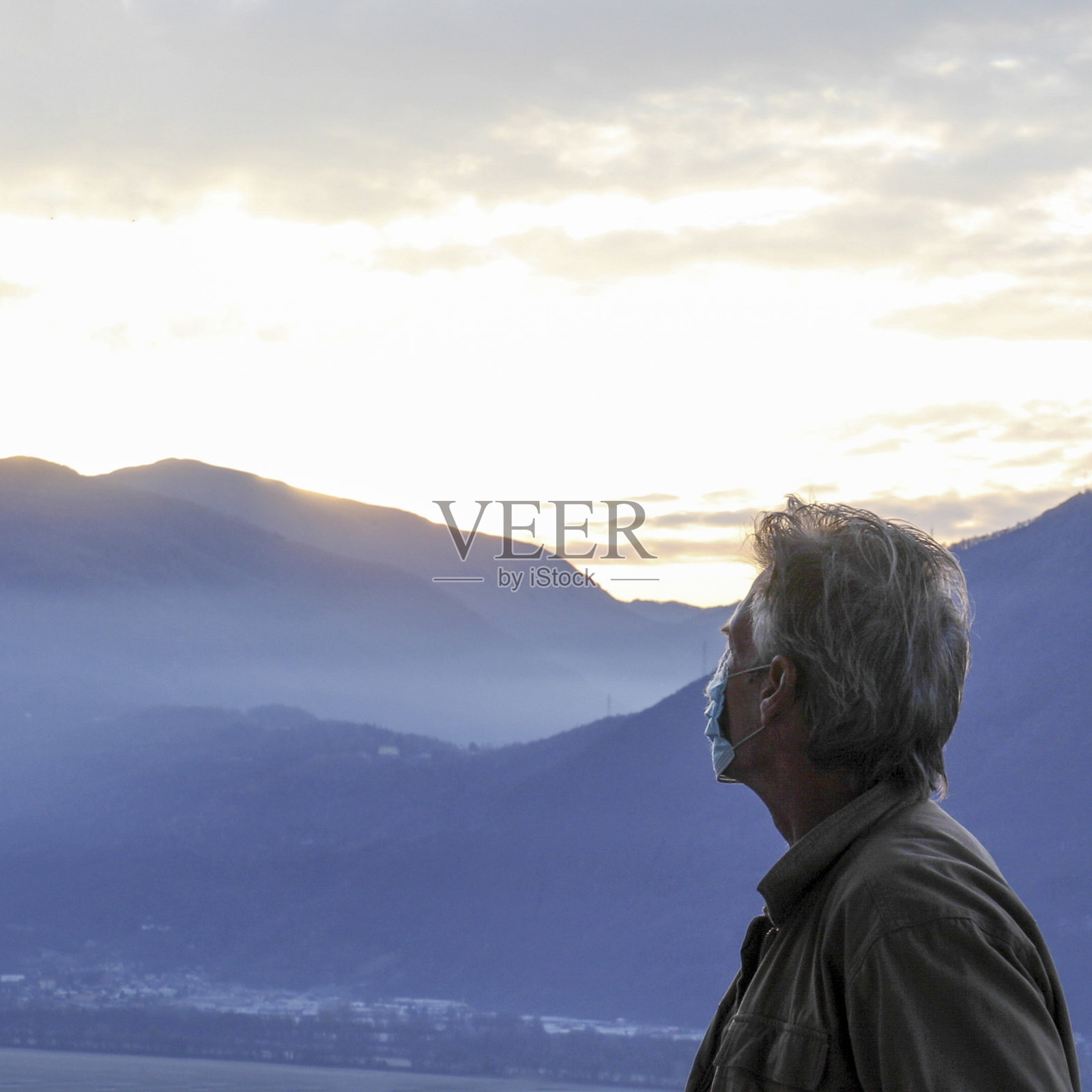 日出时分，戴着防护面罩的男子在户外放松照片摄影图片