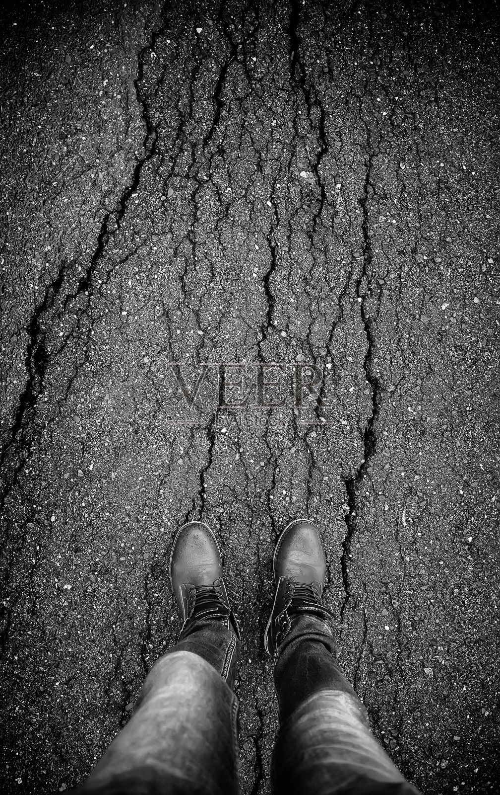 脚踩在开裂的沥青上照片摄影图片