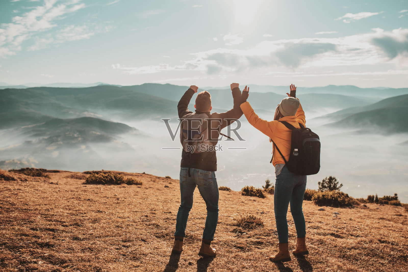在夏天徒步旅行的山顶上，一对幸福的男女游客照片摄影图片