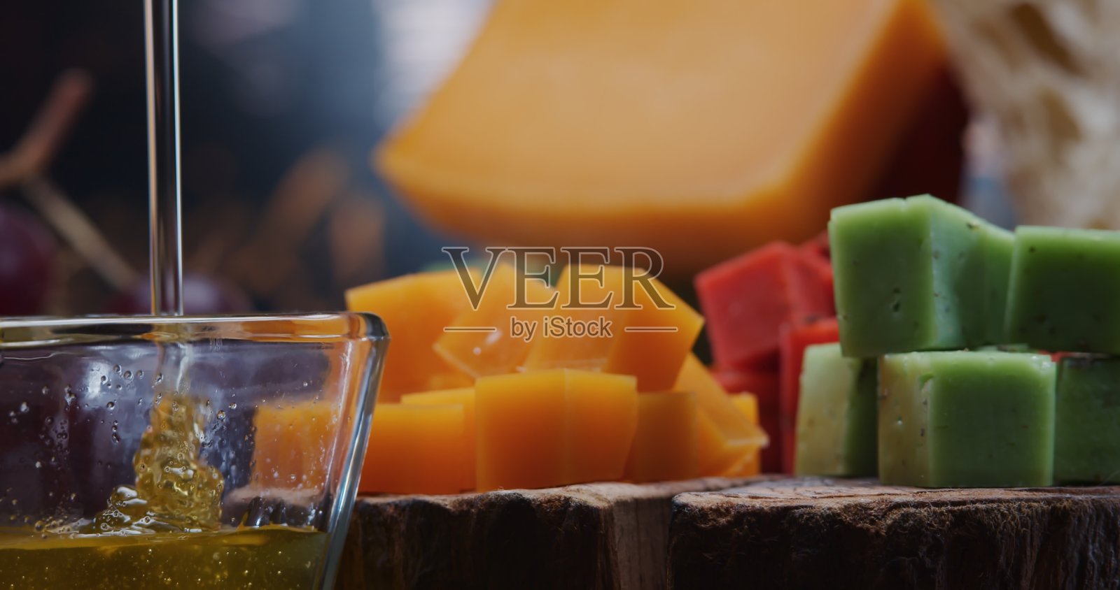 含蜂蜜和水果的多种颜色的硬奶酪。特写镜头前视图照片摄影图片