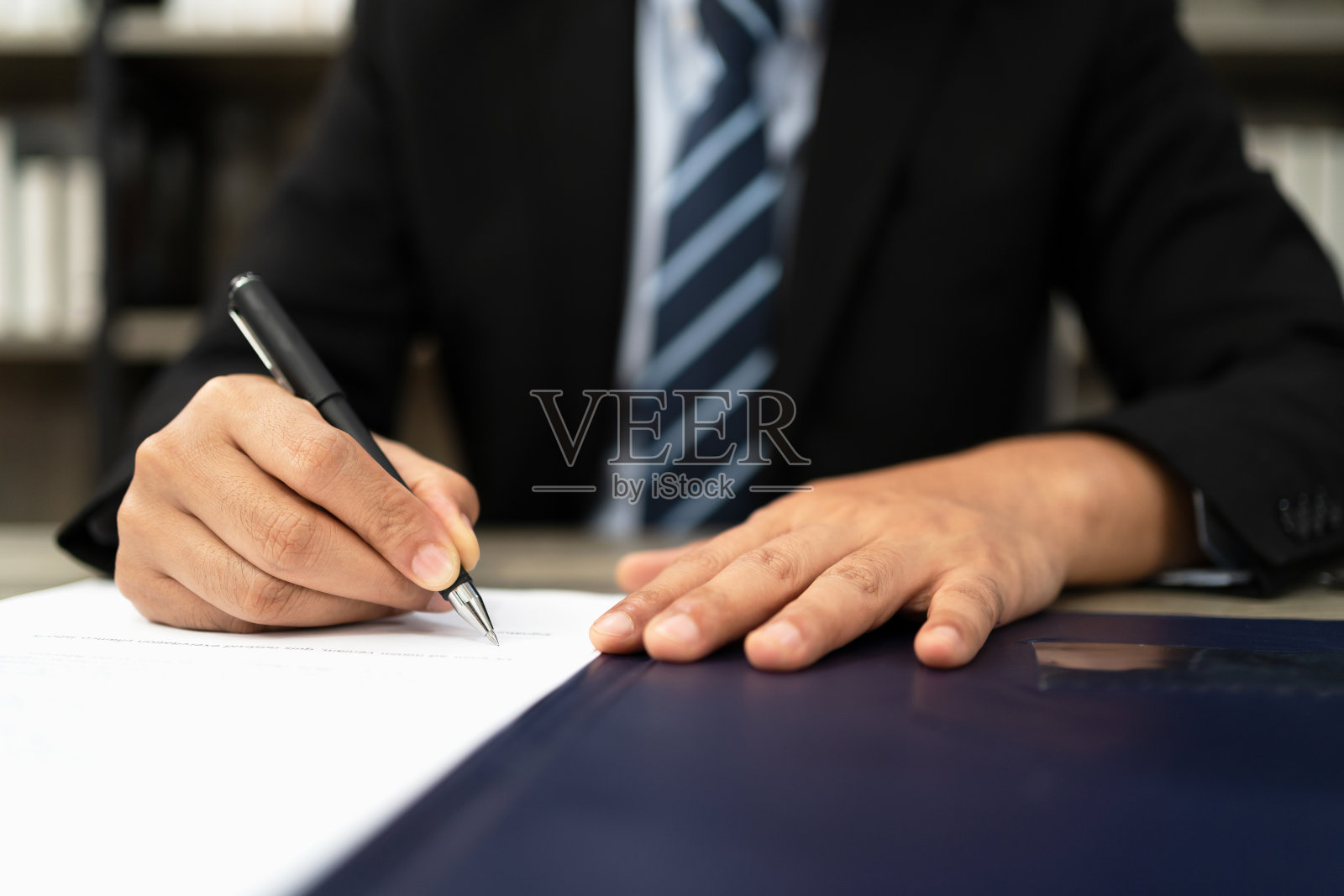 商人在办公室办公桌上签署文件照片摄影图片