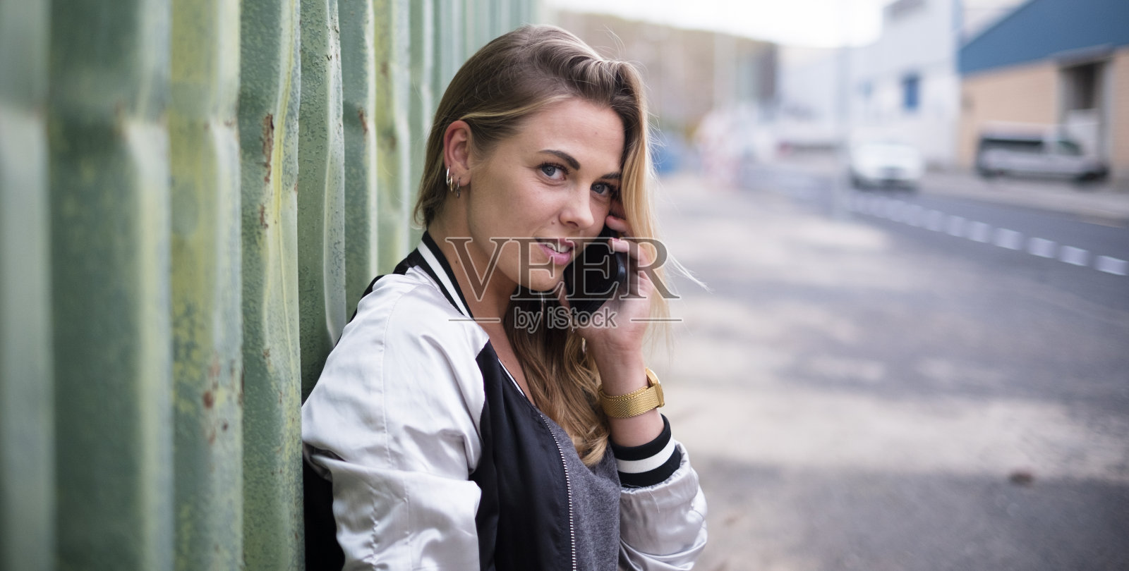 美丽的近距离美丽的金发女人笑着对她的手机微笑-她正在使用她的手机-网上的生活方式照片摄影图片