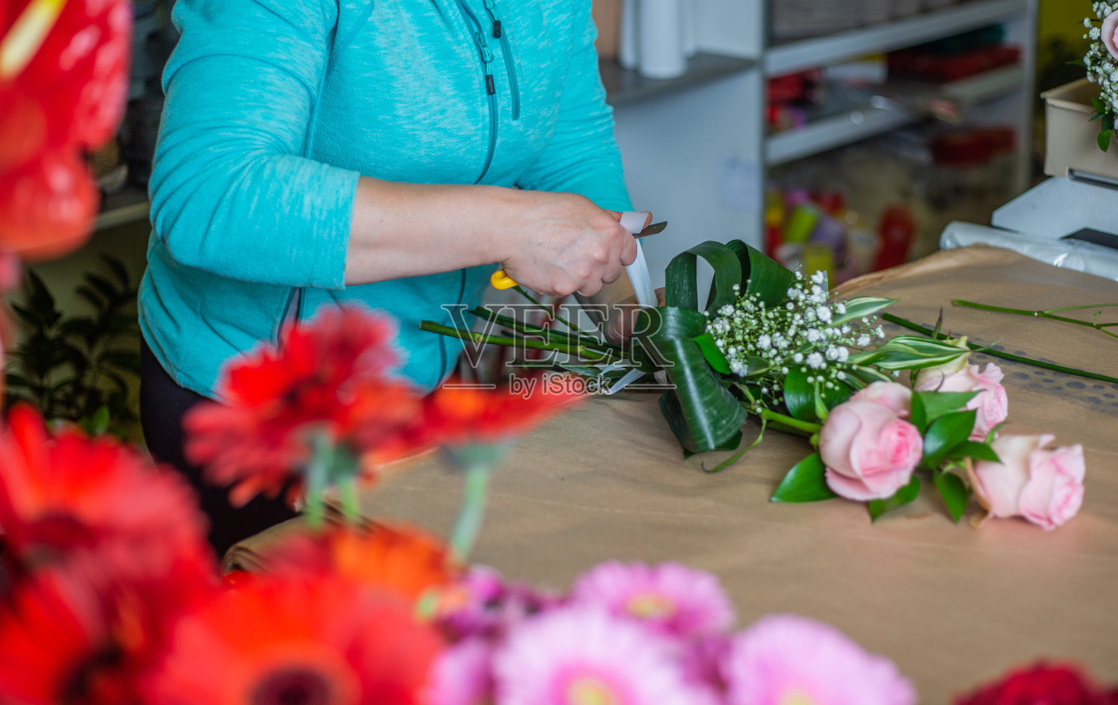 花店女花匠在花店用玫瑰系花束照片摄影图片