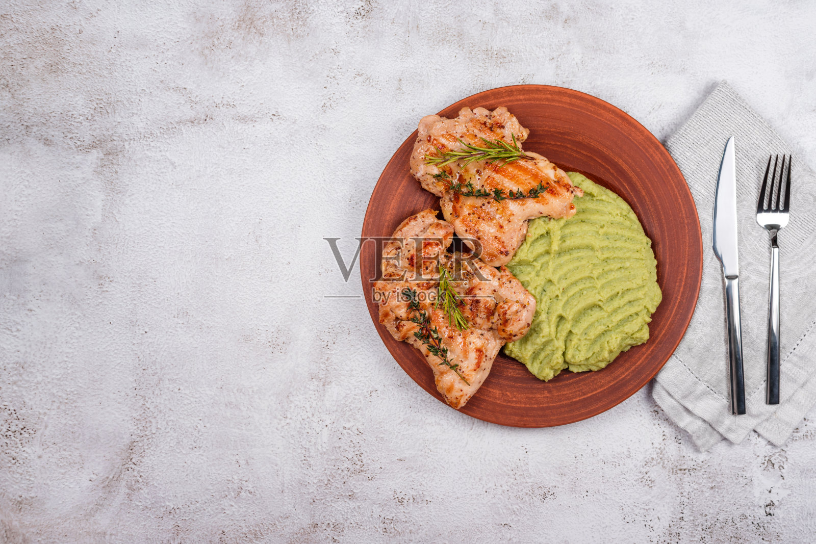 美味的烤鸡配香草和绿泥。鸡柳配土豆泥、青豆和香蒜沙司。健康的自制食品。平放，俯视图，文本空间照片摄影图片