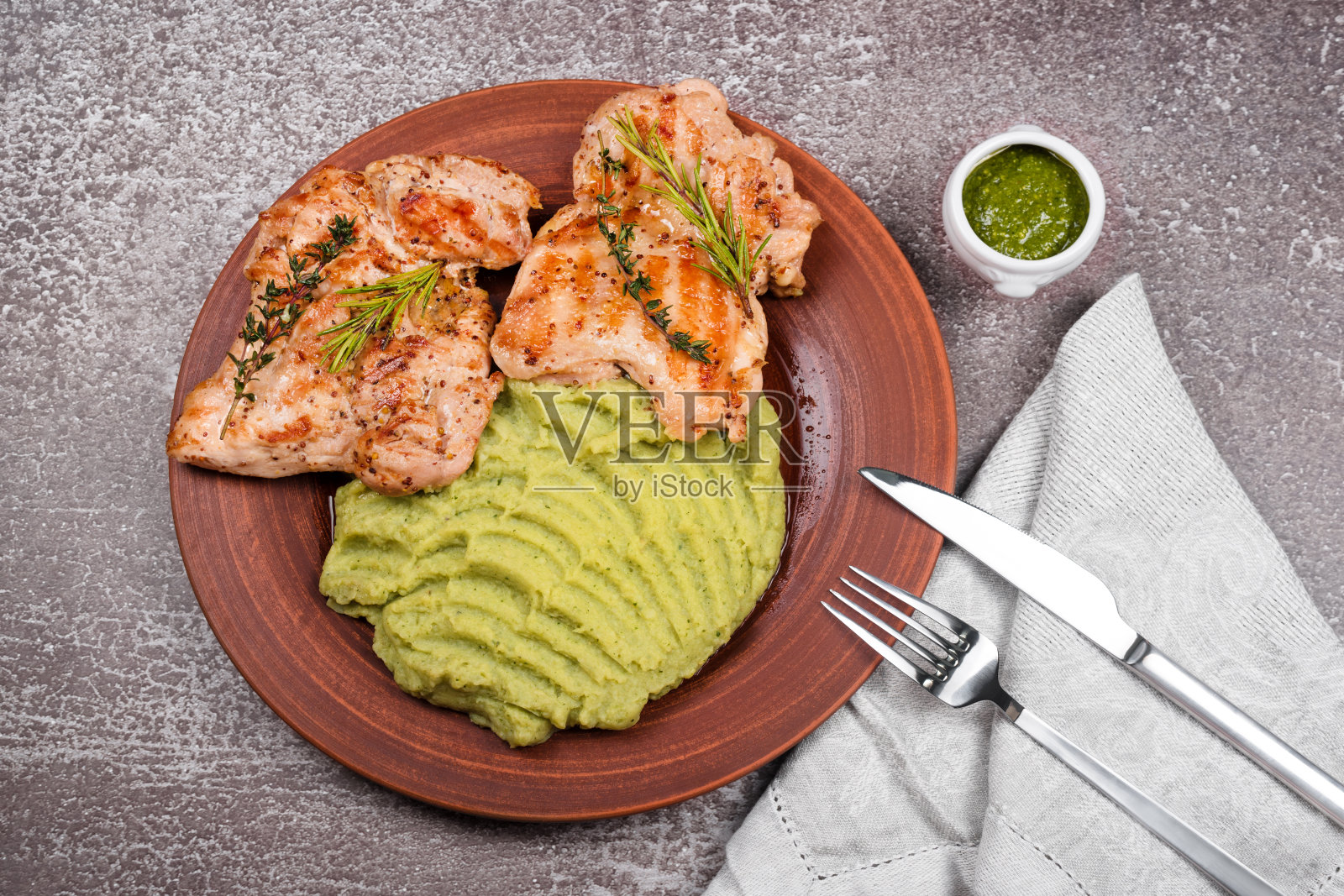 美味的烤鸡配香草和绿泥。鸡柳配土豆泥、青豆和香蒜沙司。健康的自制食品。平躺，俯视图。照片摄影图片