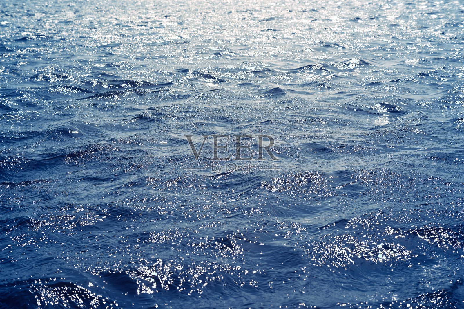 蓝色暗色的水波荡漾水面背景，阳光反射照片摄影图片