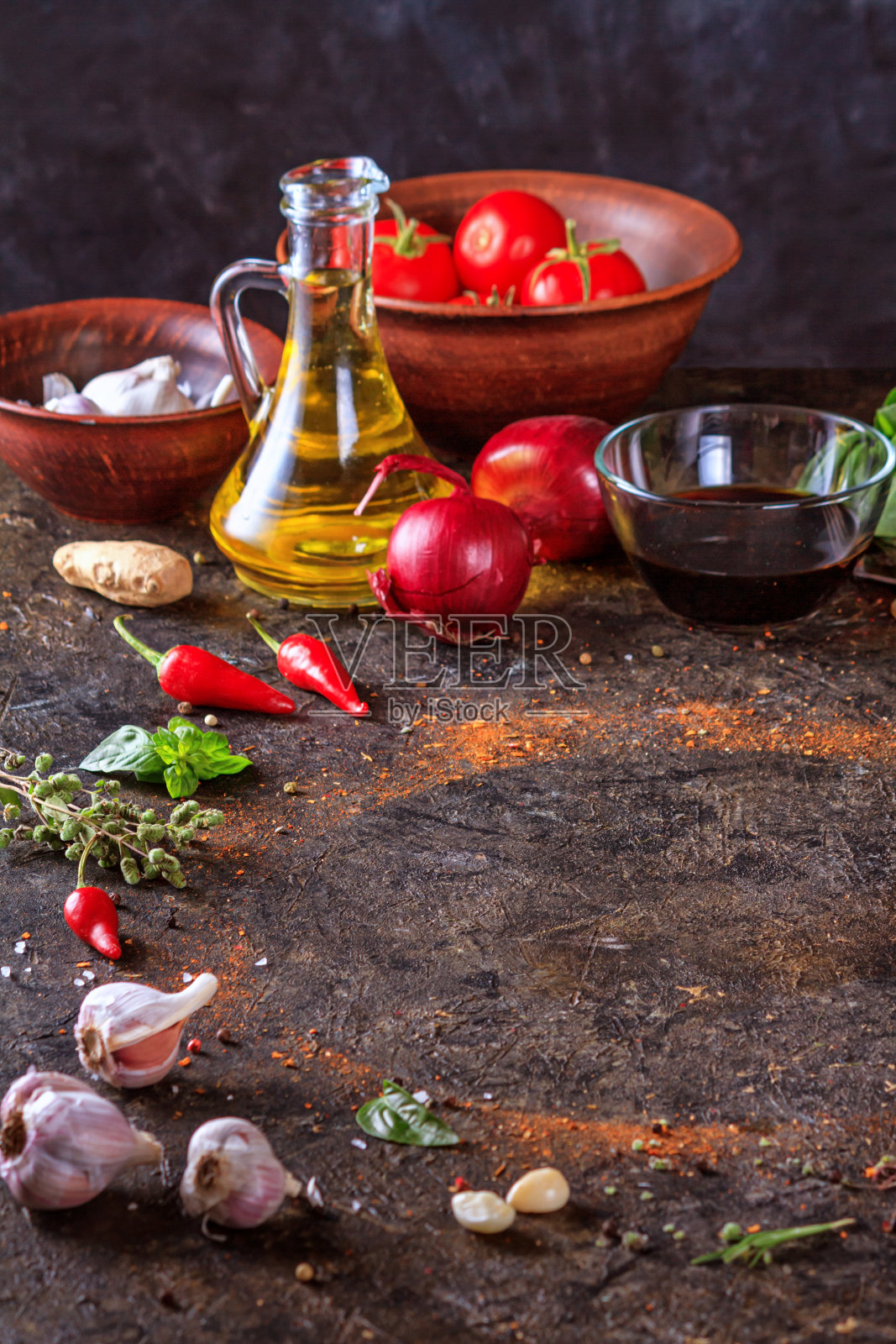 烹饪背景与厨房石材表面，橄榄油在一个罐子和蔬菜照片摄影图片