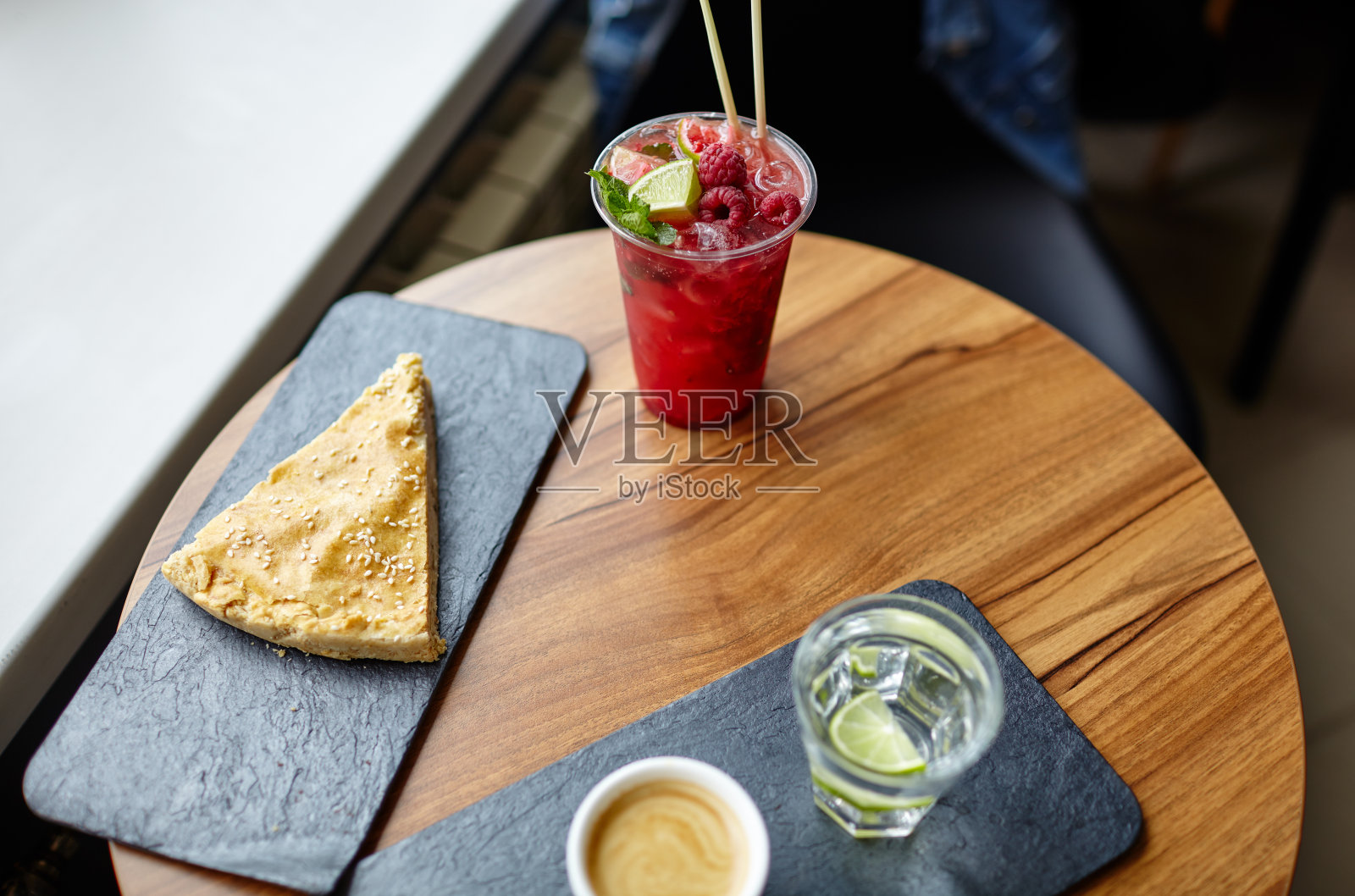 桌上放一块派的石头盘子，咖啡里的莫吉托鸡尾酒或水果苏打饮料照片摄影图片