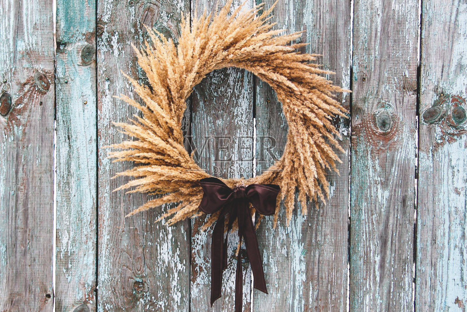 在木板背景上的干花花环。古董。室内花环。干花作为家居装饰的元素照片摄影图片