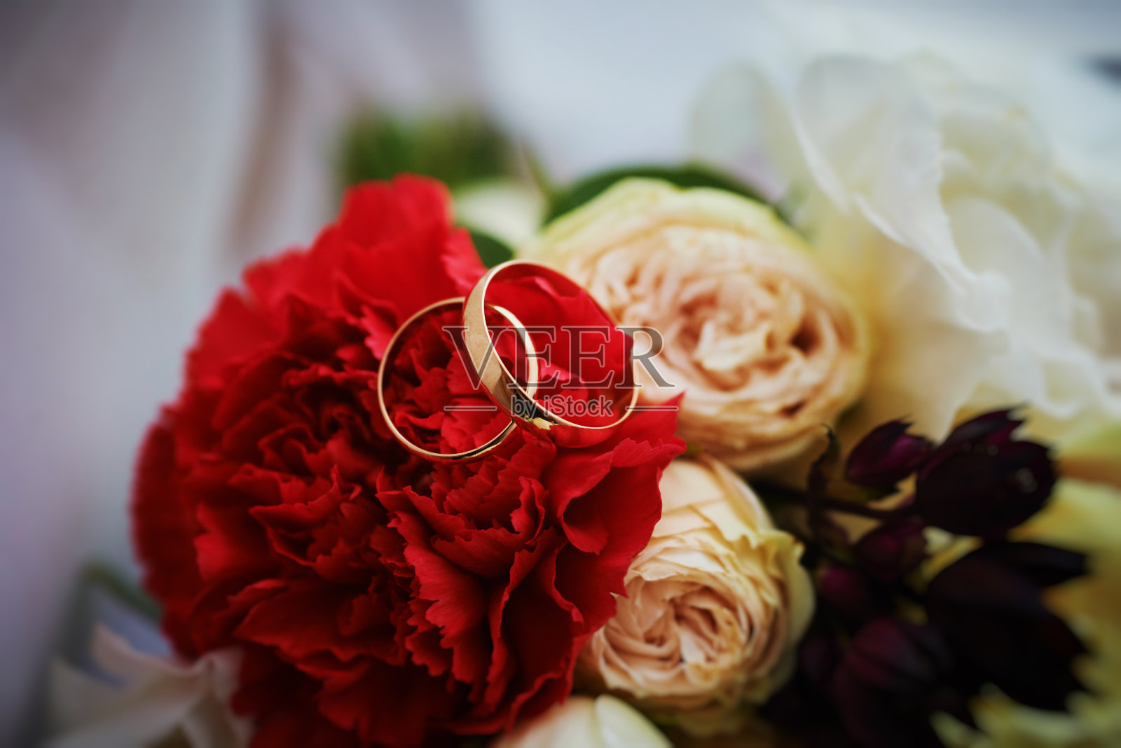 金戒指和美丽的新娘玫瑰花束作为背景。细节,婚礼传统。特写、宏照片摄影图片