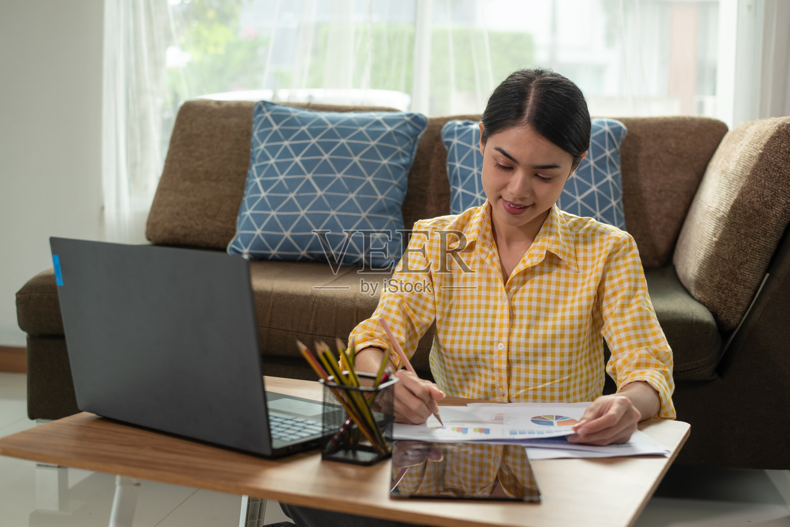 年轻的亚洲女商人在她的家里用笔记本电脑工作，在家工作，商业概念照片摄影图片