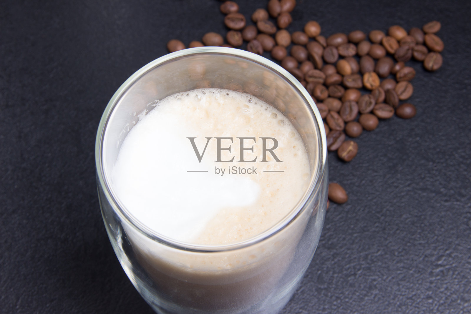 一杯拿铁咖啡和咖啡种子在黑色的背景照片摄影图片