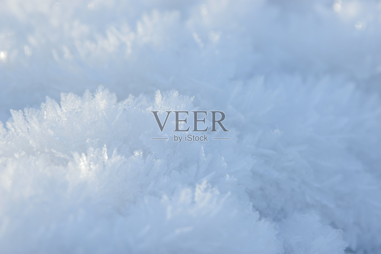 白霜背景纹理。新鲜的冰和雪的冬天背景与雪花和山丘。季节性的壁纸。冰冻水的几何形状和图形。天气寒冷，大气降水。照片摄影图片