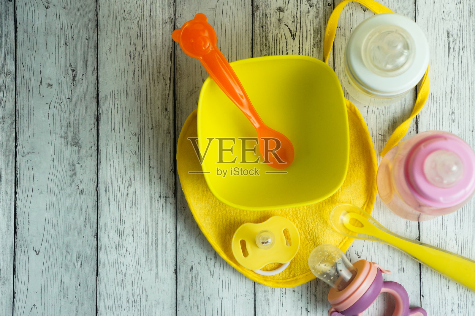 明亮的婴儿奶瓶，盘子，勺子和轻咬，婴儿食品概念照片摄影图片