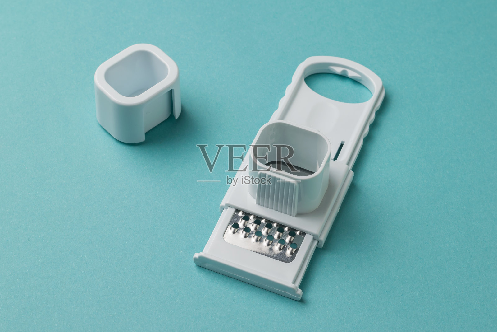 蓝色背景上的大蒜和巧克力磨碎器。照片摄影图片