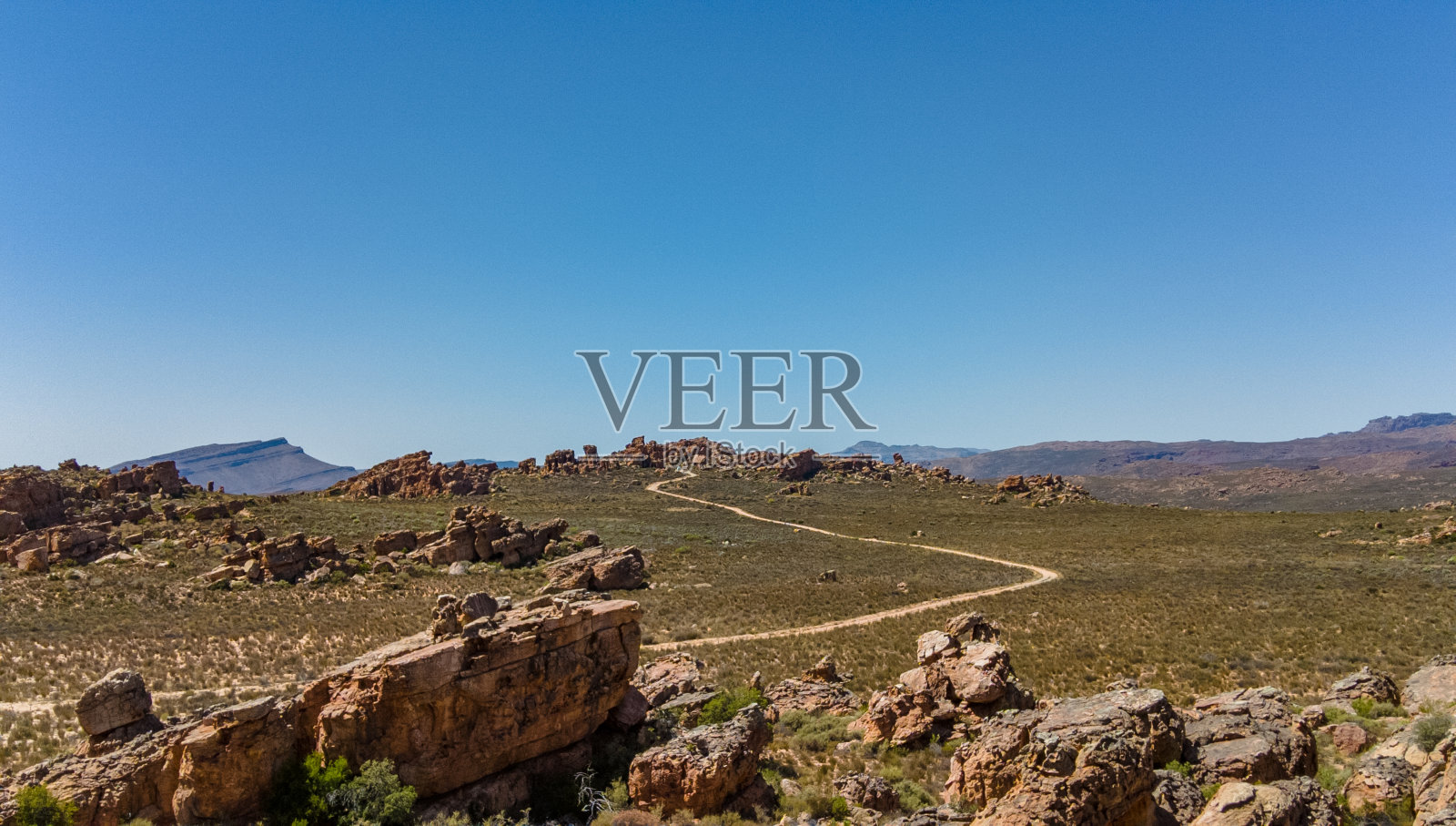 沙土中通往岩层的蜿蜒道路照片摄影图片