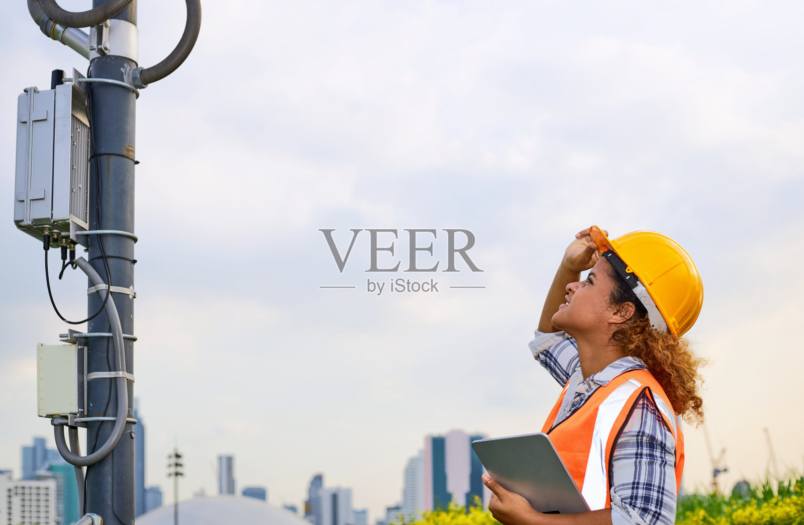 非裔美国女工程师正在检查通信塔是否准备就绪。照片摄影图片