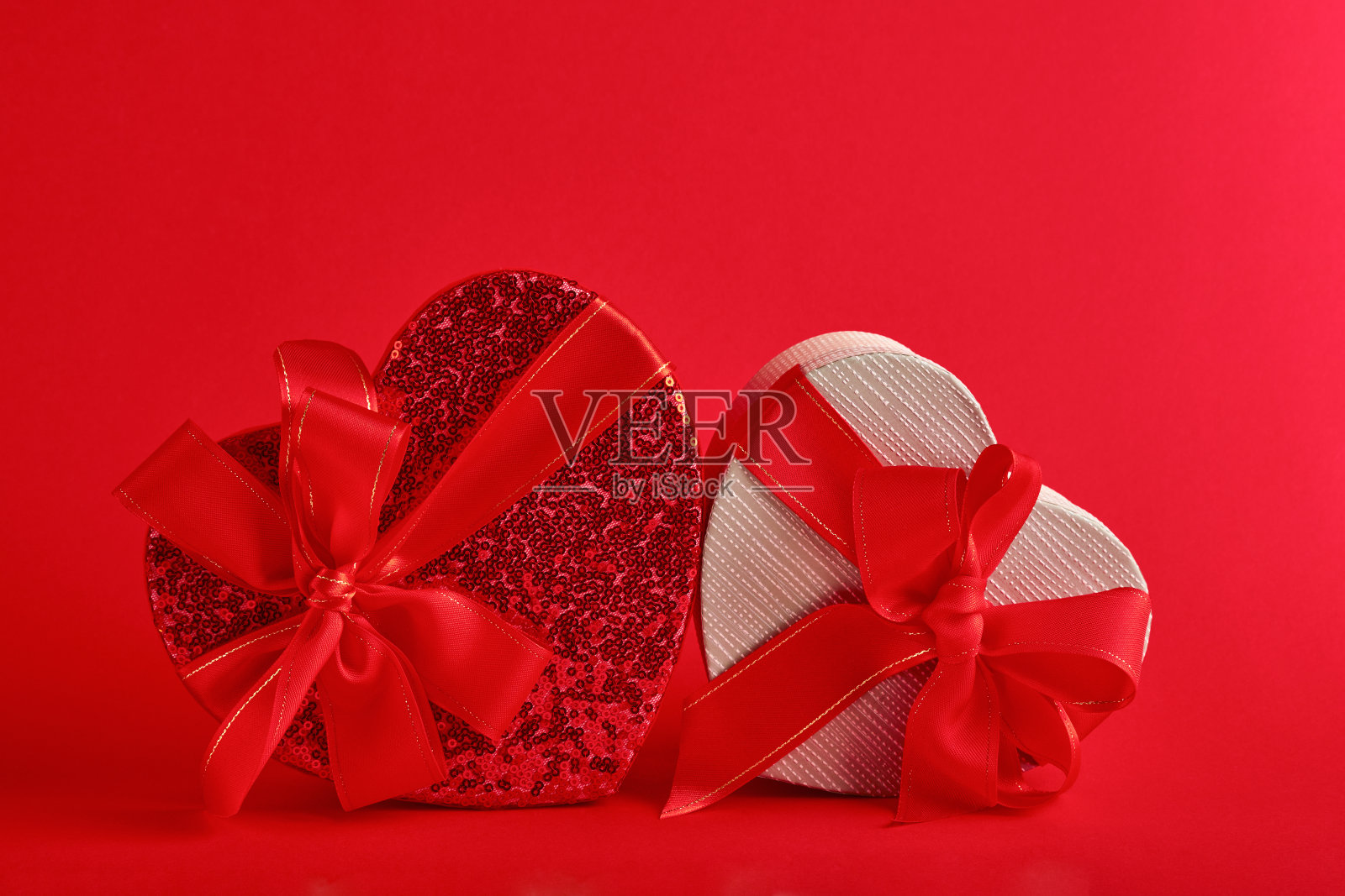 各种选择的心形礼盒，红色背景上有一条红丝带。情人节概念明信片。俯视图平铺与复制空间。照片摄影图片