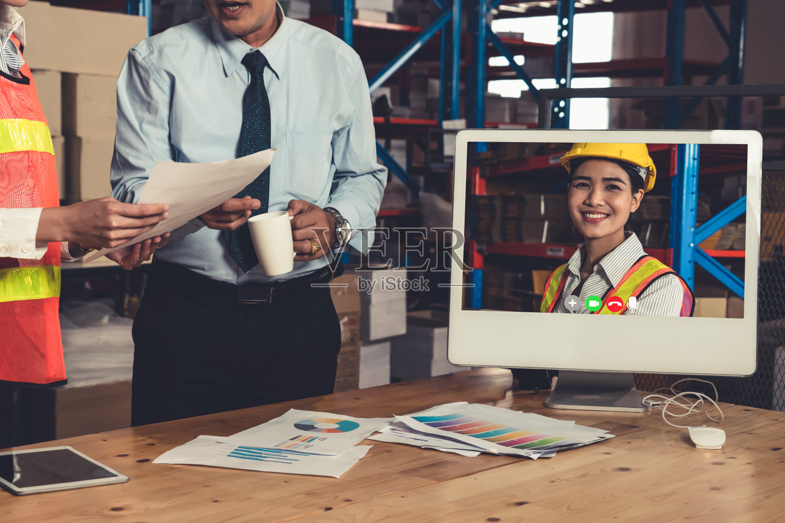 仓库工作人员在仓库的电脑屏幕上进行视频通话照片摄影图片