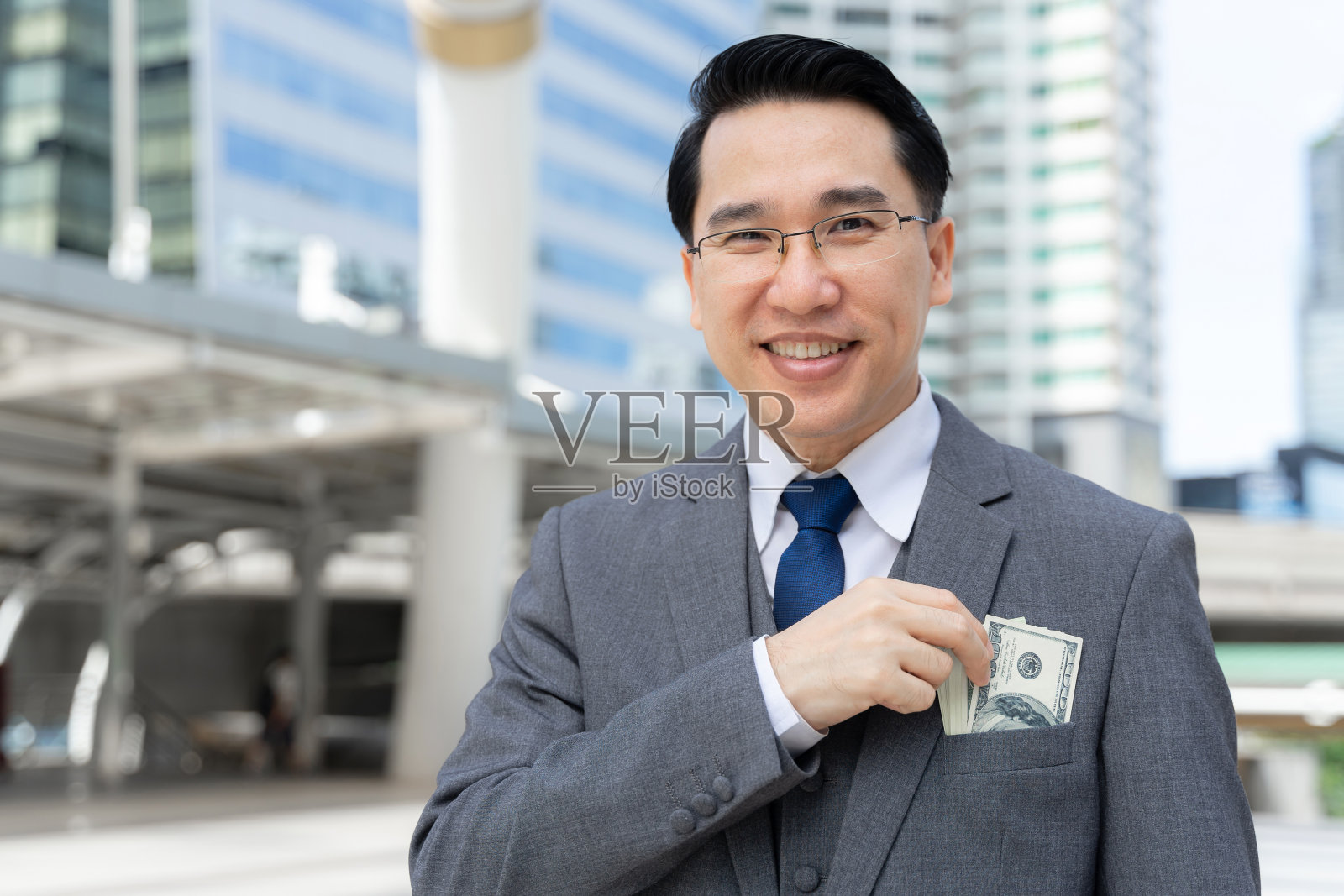 商人手里拿着钞票在商务区，有钱人商业成功的概念照片摄影图片