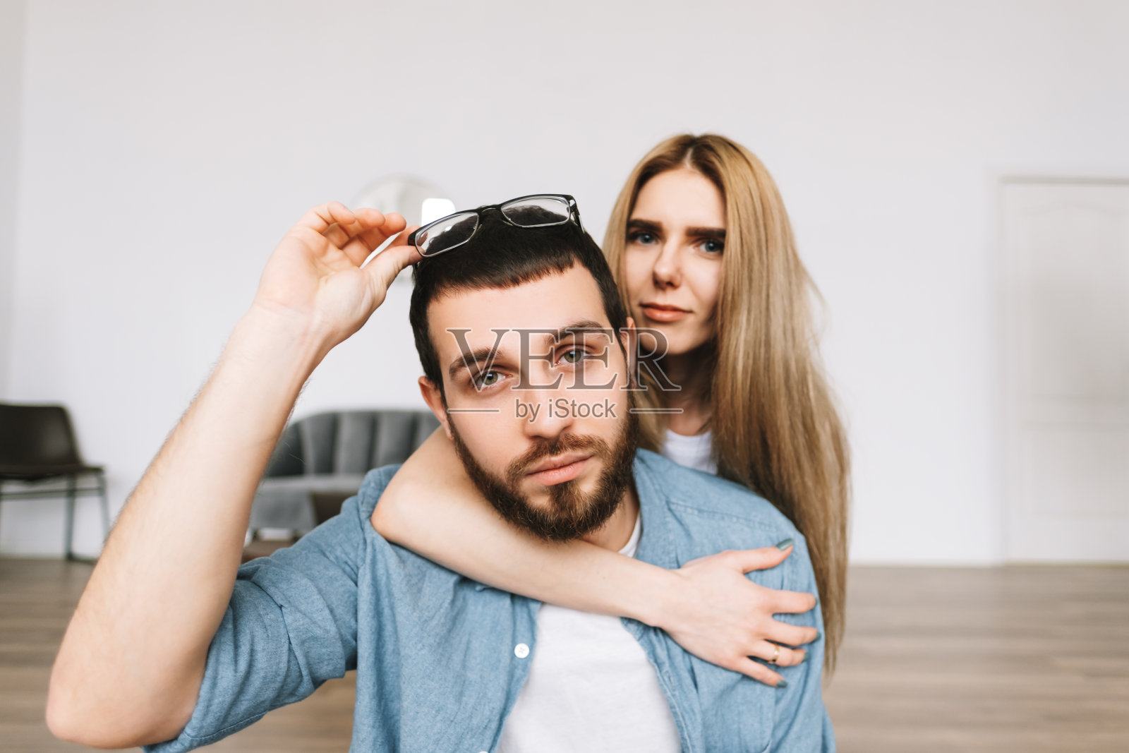 一对愉快的夫妇坐在新公寓的地板上。照片摄影图片