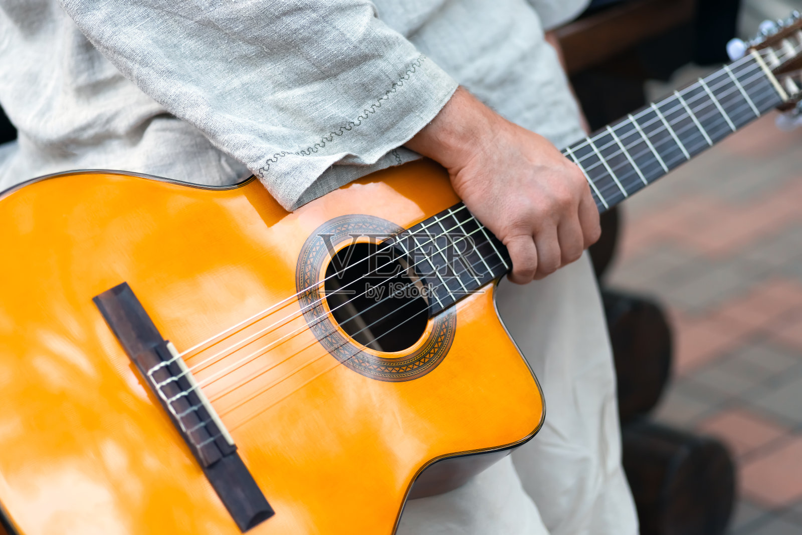 原声黄色古典吉他在一个男人的手中照片摄影图片
