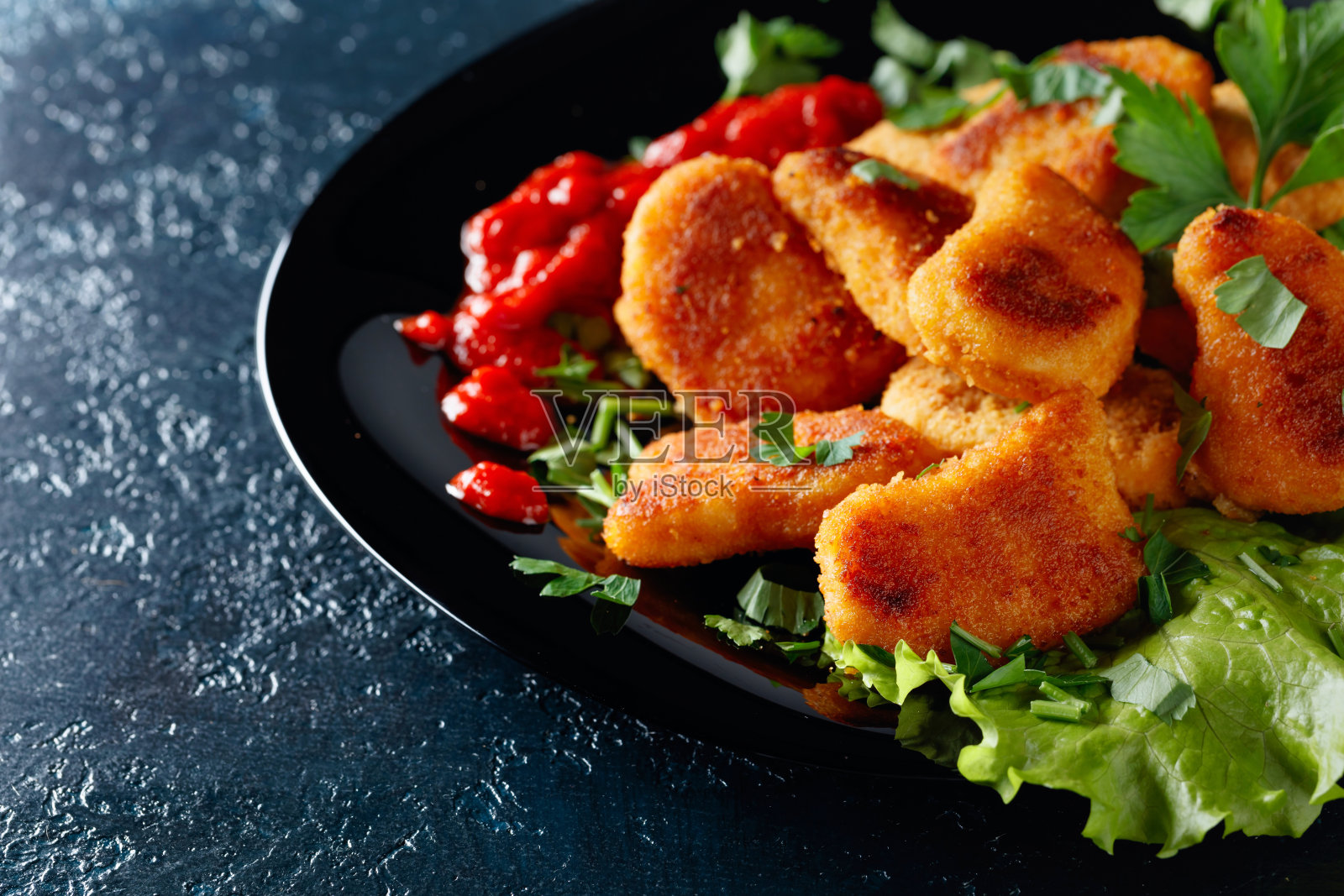 炸鸡块配番茄酱。照片摄影图片