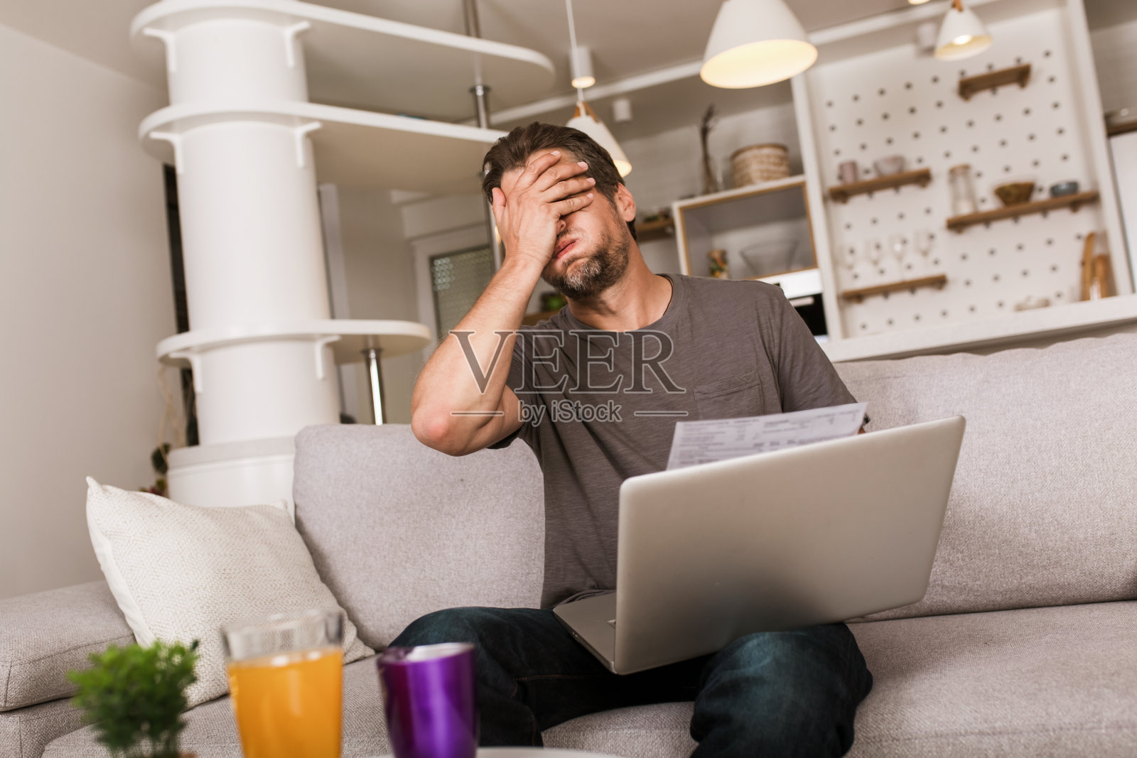 一个男人在家里用笔记本电脑付账。照片摄影图片