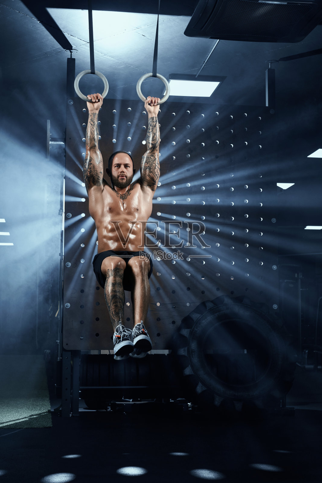 用吊环训练腹肌的运动员。照片摄影图片