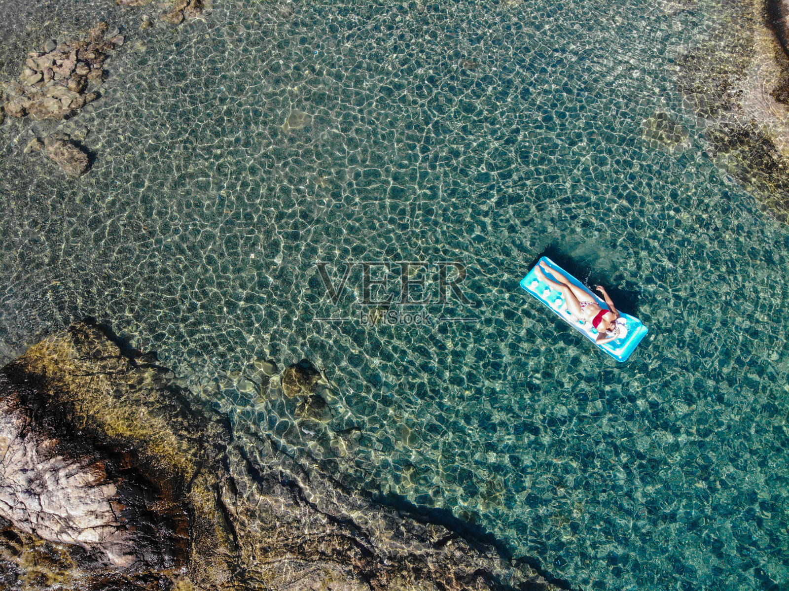 美丽的女人在海上的充气床垫上休息。照片摄影图片
