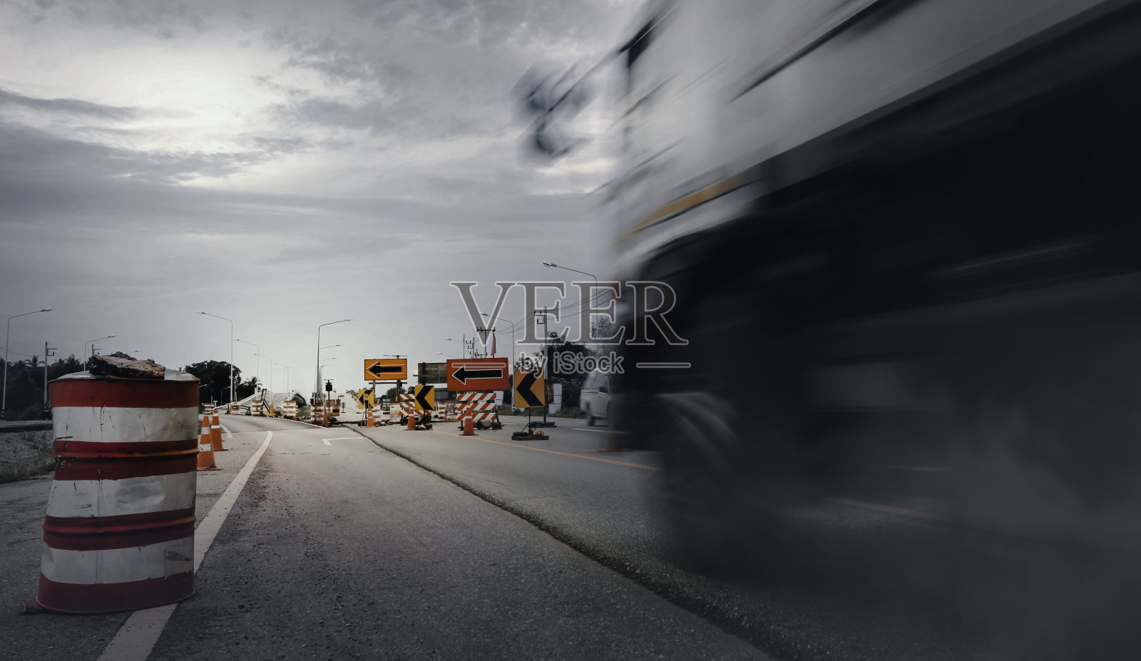 模糊的大卡车通过临时状况道路警告标志。照片摄影图片