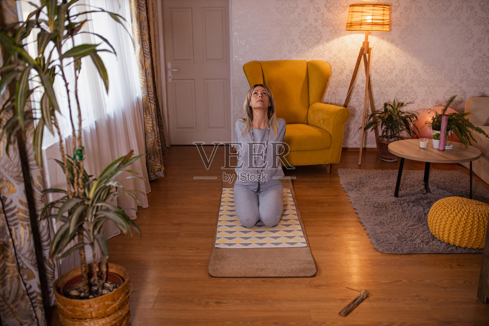 穿着运动服在家练习瑜伽的苗条女人。照片摄影图片