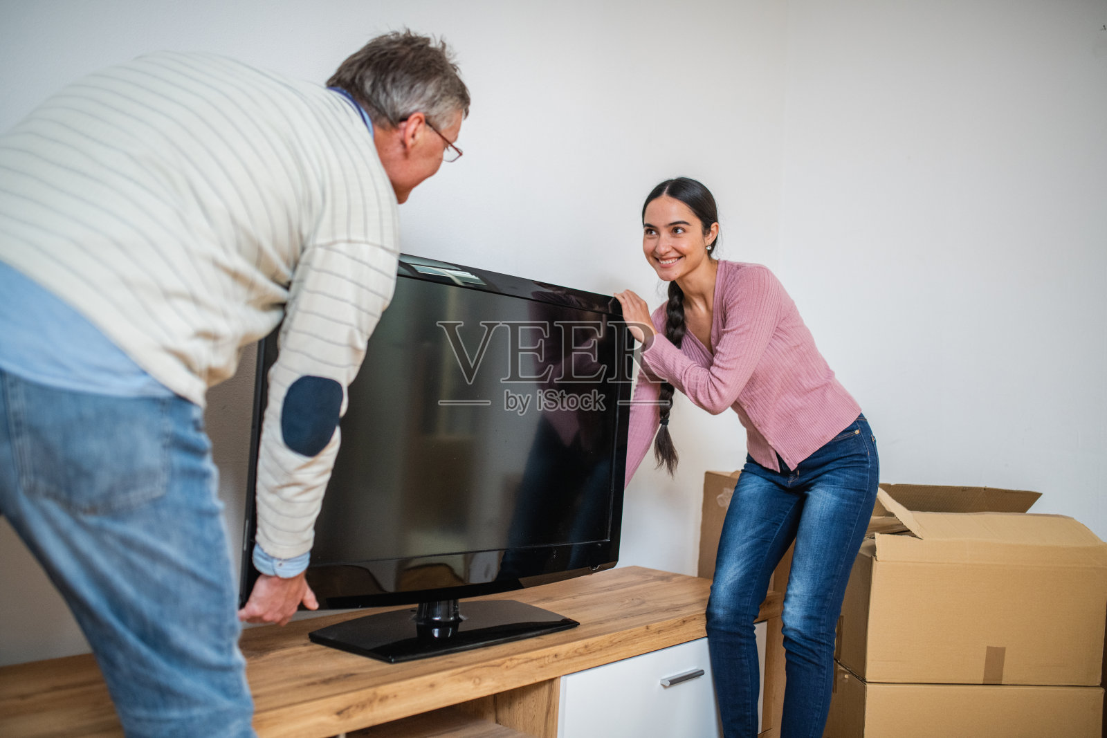 爸爸和女儿把电视搬进新公寓照片摄影图片