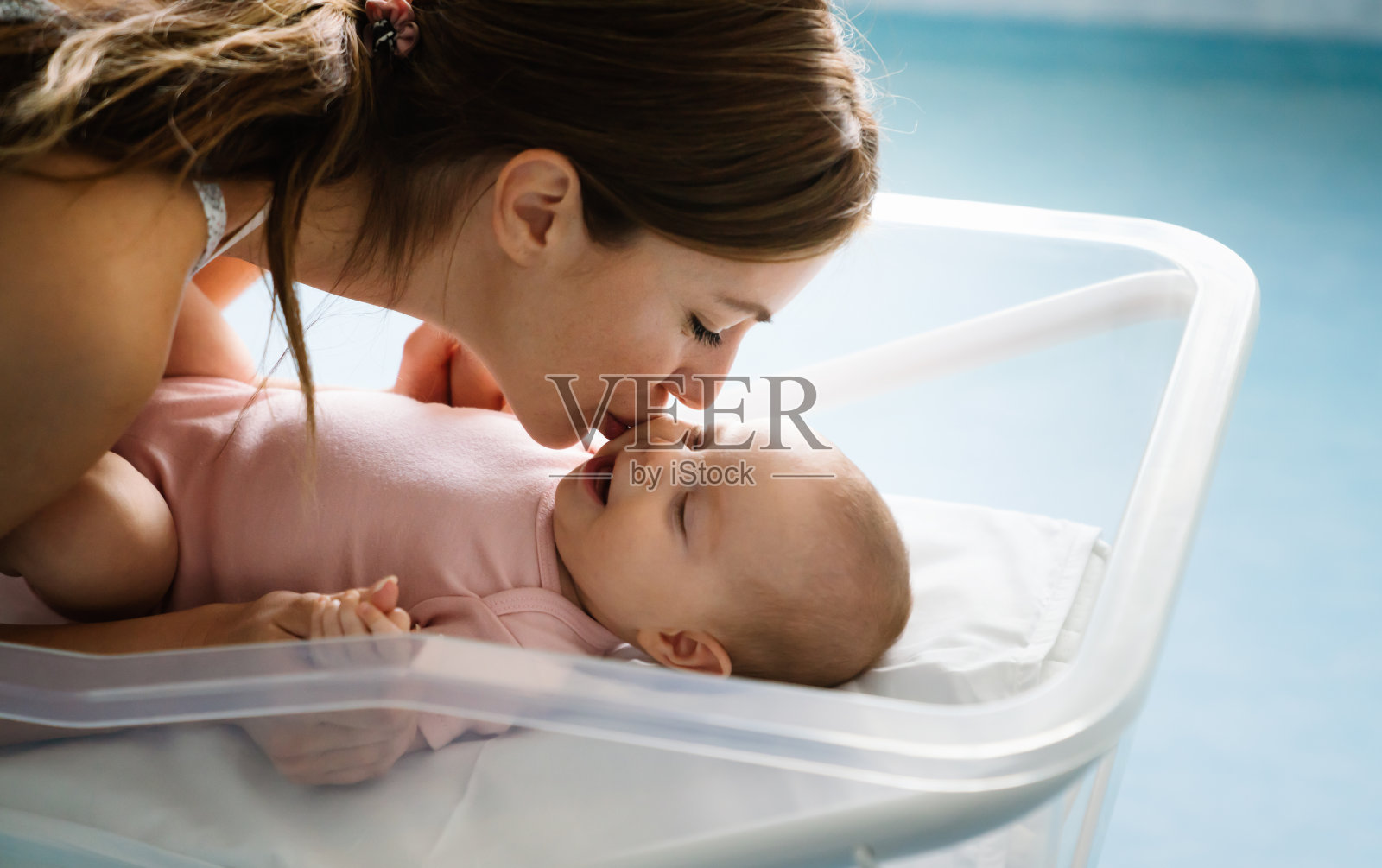 幸福快乐的家庭。妈妈和宝宝接吻，大笑，拥抱照片摄影图片