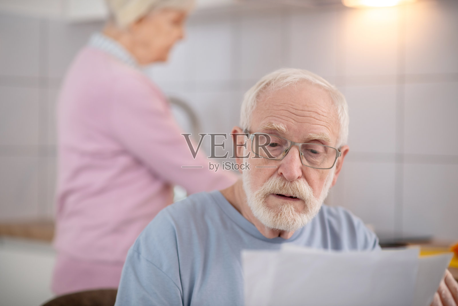 满脸胡须的老人在看什么东西，看上去很严肃照片摄影图片