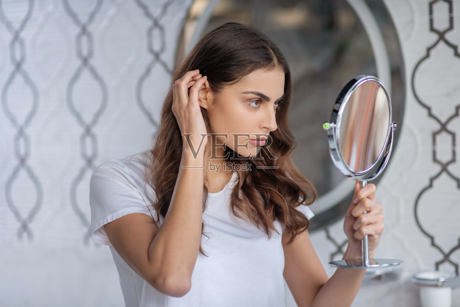 女人看着便携式小镜子照片摄影图片