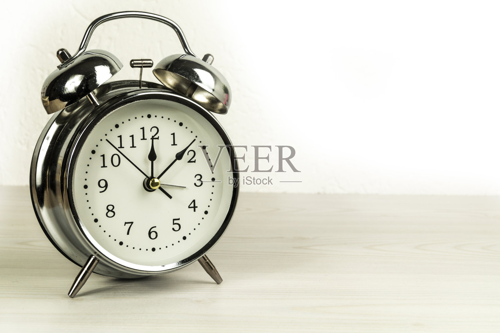 桌子上的银色复古闹钟。照片摄影图片