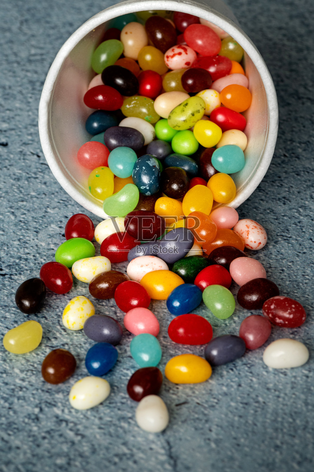 糖豆从白色泡沫杯里溢出来照片摄影图片