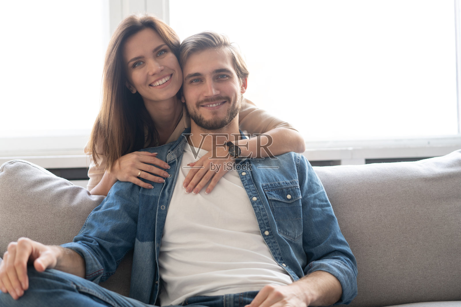 幸福的夫妇或婚姻拥抱和享受在家里的沙发上。照片摄影图片