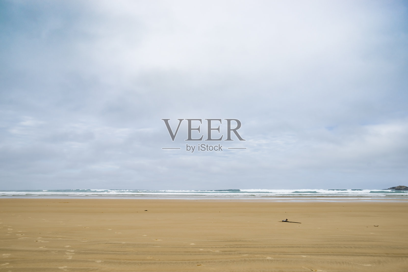 在极简主义风格的时代，宽阔广阔的平坦海滩与退潮和低浪打破地平线照片摄影图片