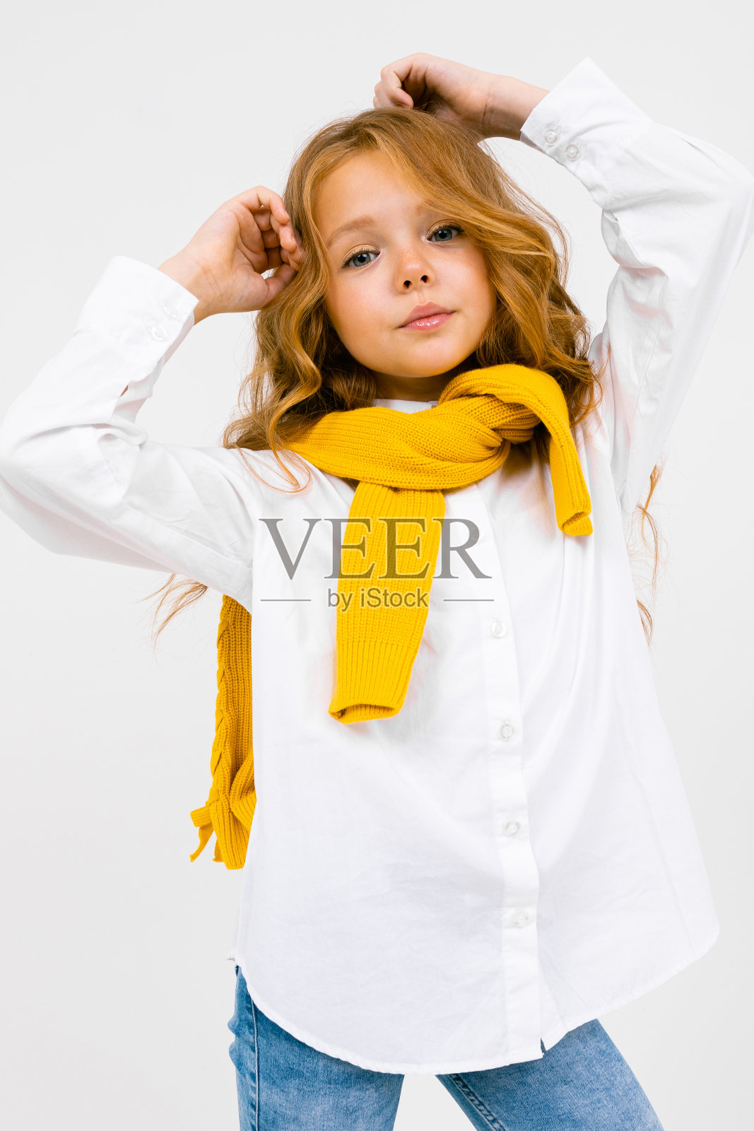 十几岁的女孩在白色衬衫和牛仔裤摆姿势在一个白色孤立的背景照片摄影图片