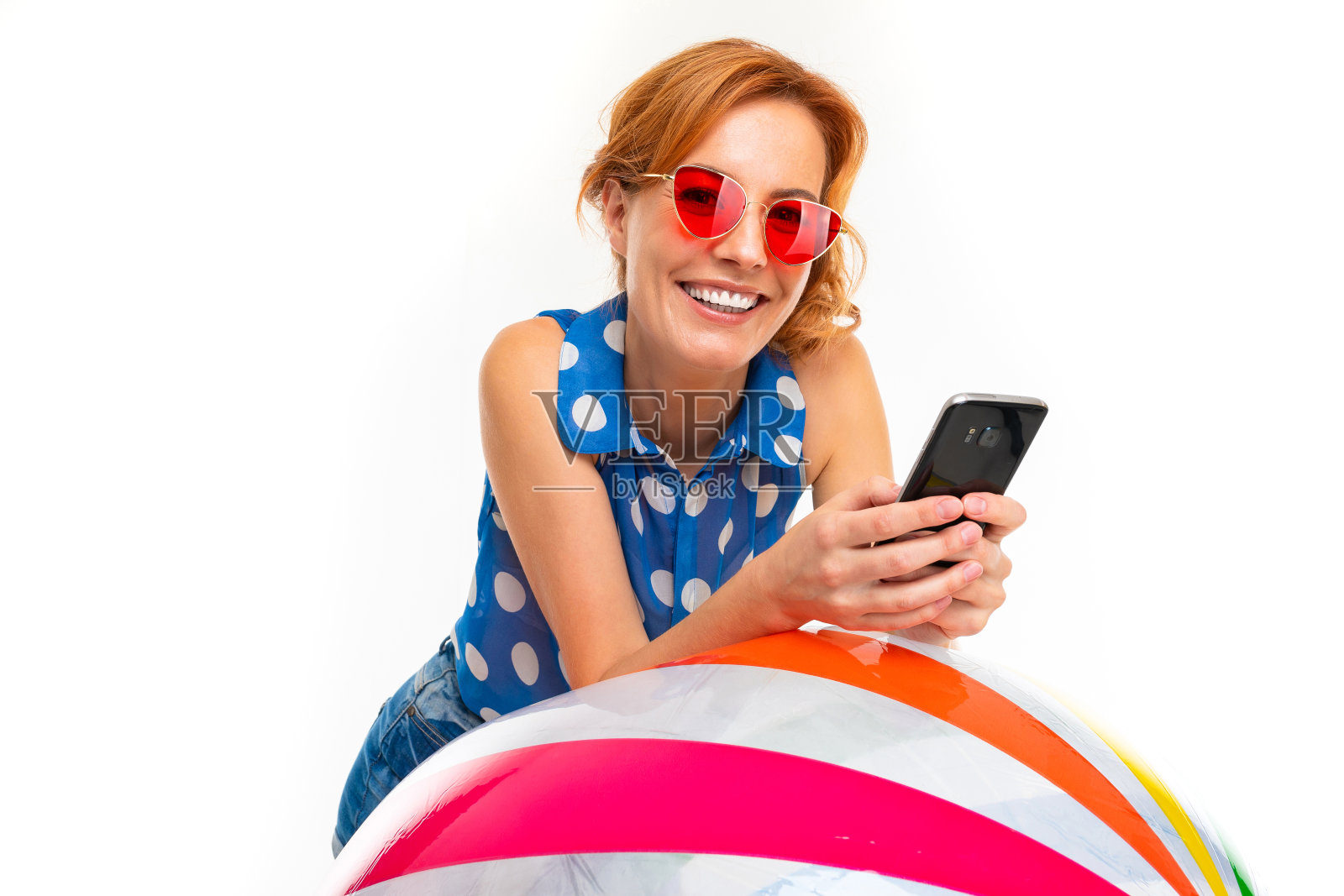 一个有着浅红色头发的快乐女人拿着一个球，画面孤立在白色的背景上照片摄影图片