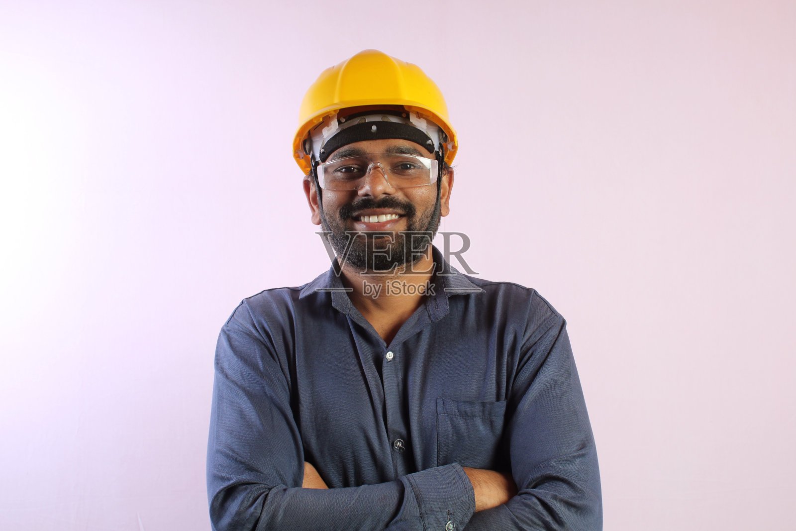 亚洲男性工程师在办公室检查和工作，并拿着设计图。她为工作开心地笑着照片摄影图片