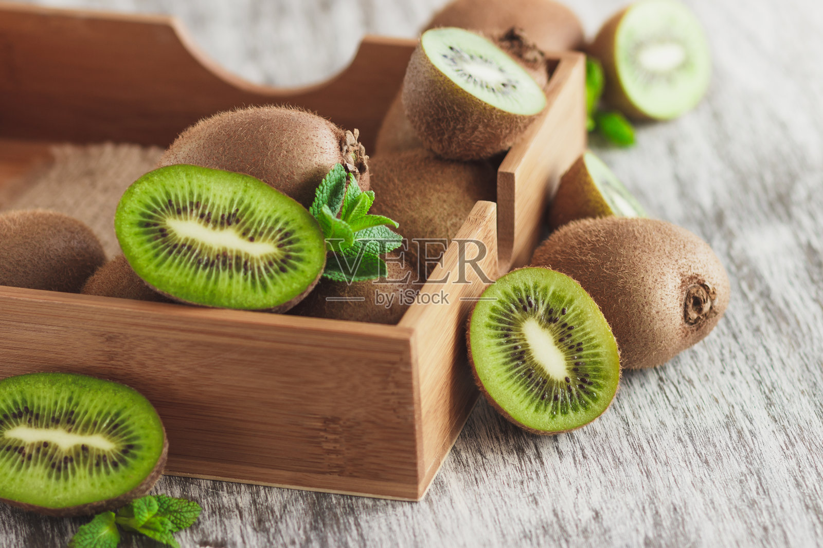 木托盘里放着绿猕猴桃和薄荷叶照片摄影图片