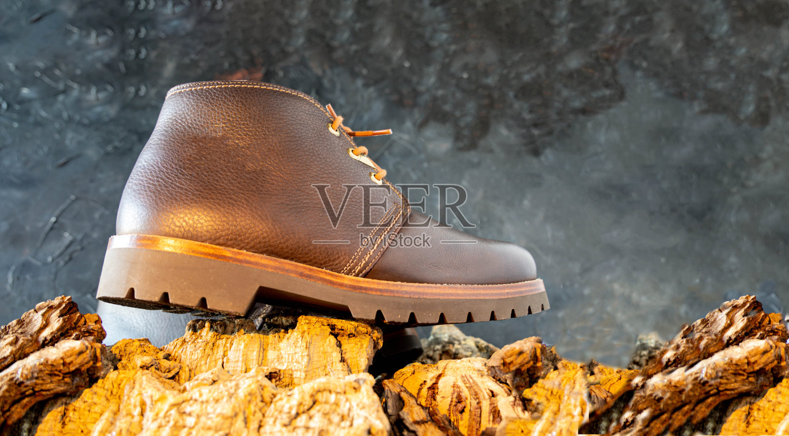 棕色皮靴上的黑色背景放置在树皮树干与复制空间和山的概念照片摄影图片