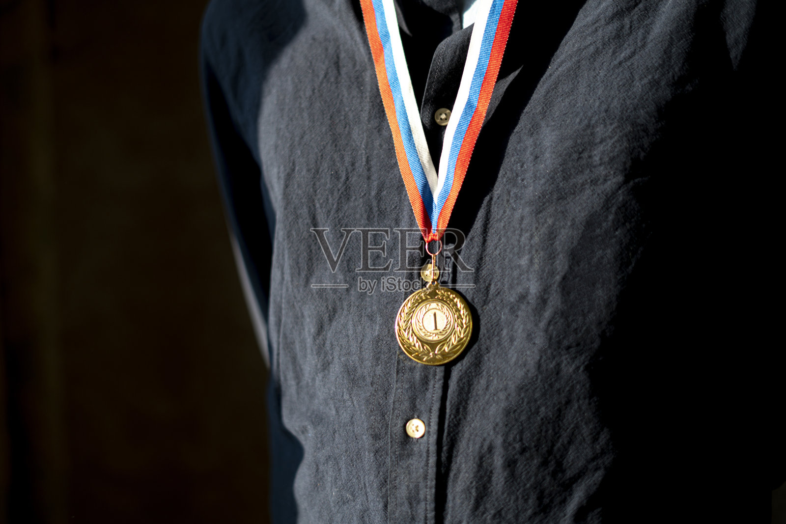 男运动员胸前戴着金牌，领跑冠军照片摄影图片